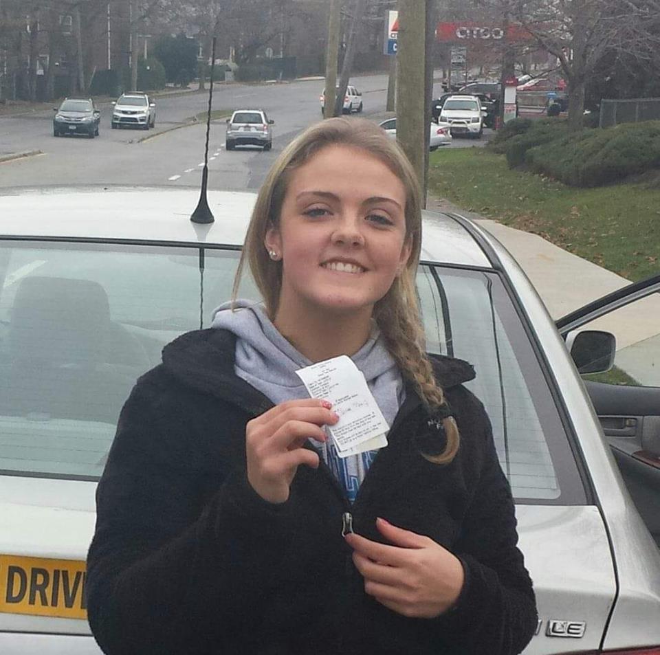 Teen driving holding her new license proudly made possible with our 5 hour class!